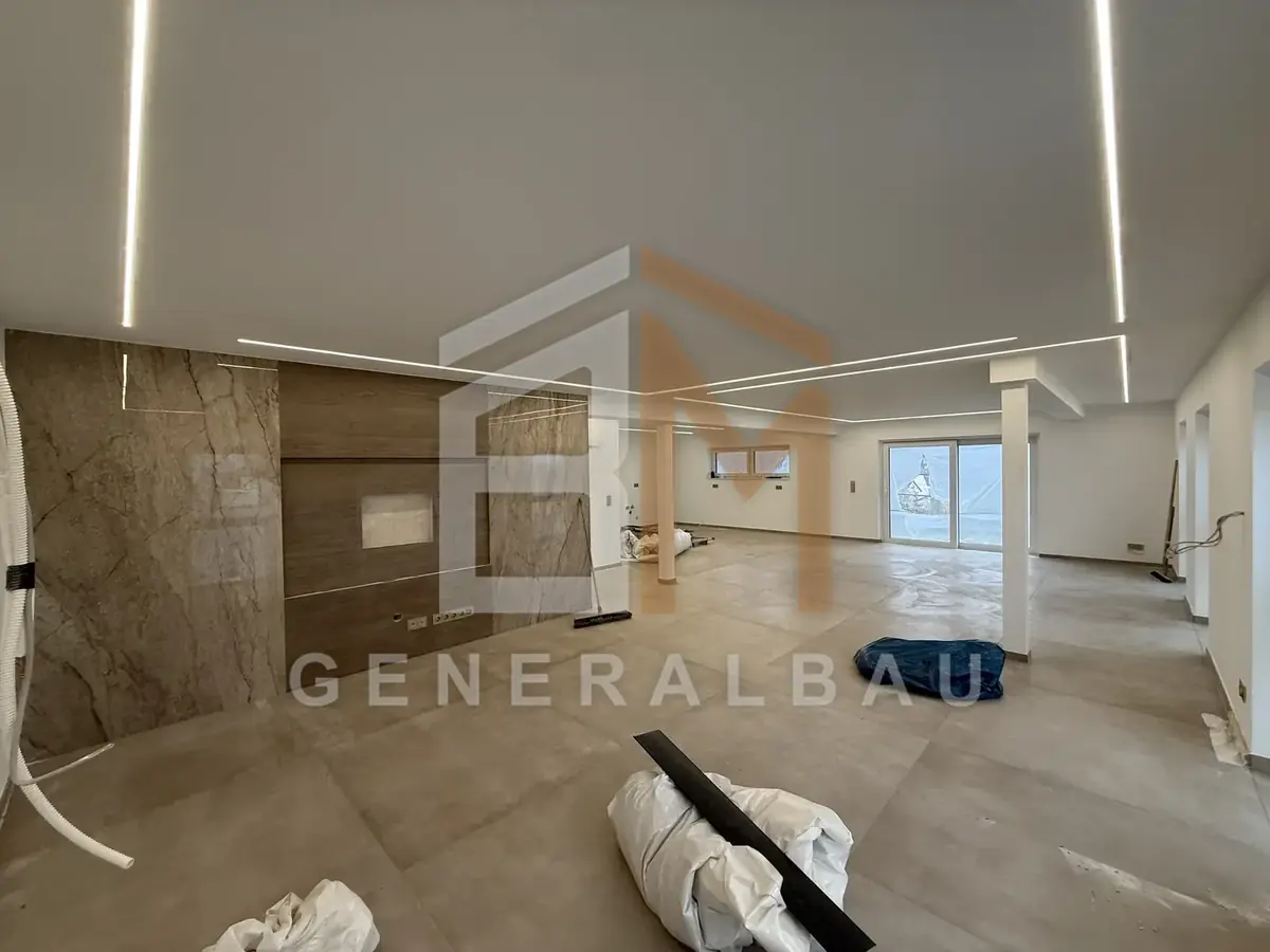 Wohnbereich mit gestalteter TV-Wand nach dem Innenausbau
