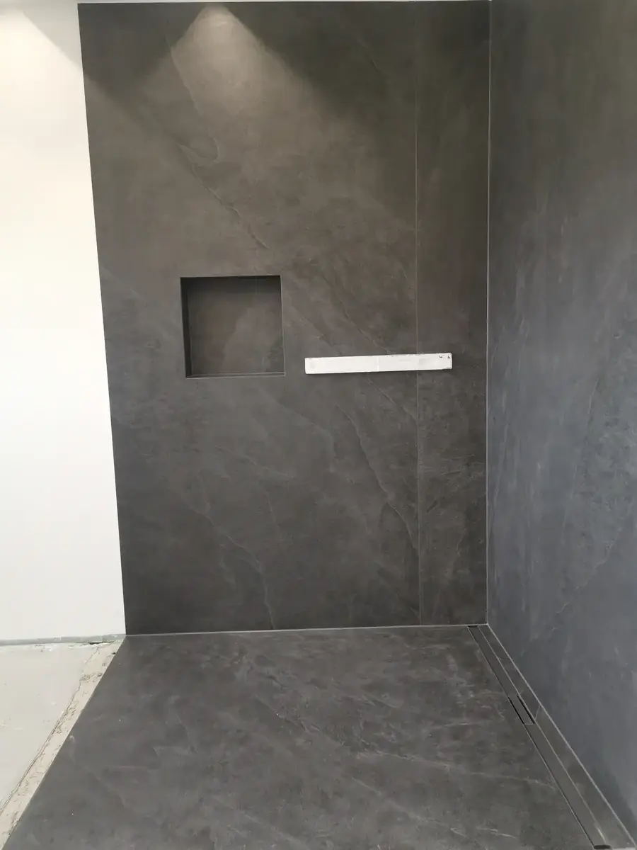 Bodengleiche Dusche mit großformatigen Wandplatten in Anthrazit