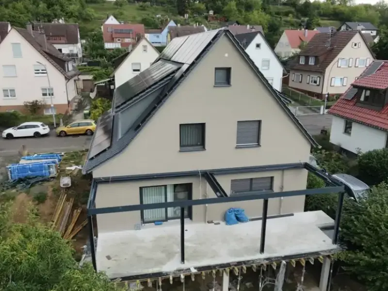 Luftaufnahme des sanierten Hauses mit Photovoltaikanlage