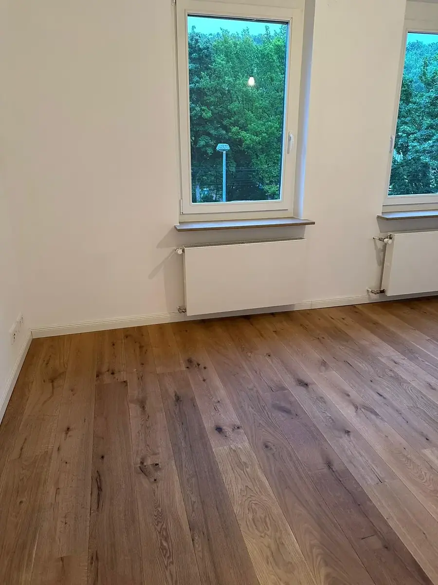 Fertig renovierter Wohnraum mit Eichendielen und neuem Heizkörper